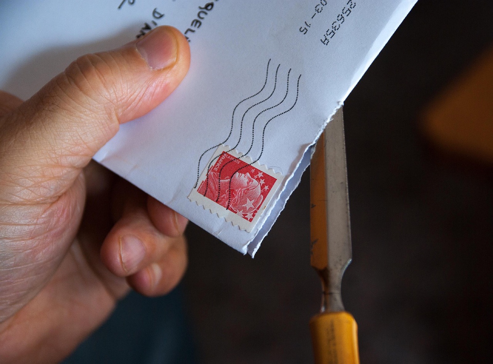 Hand holding a stamped paper envelope