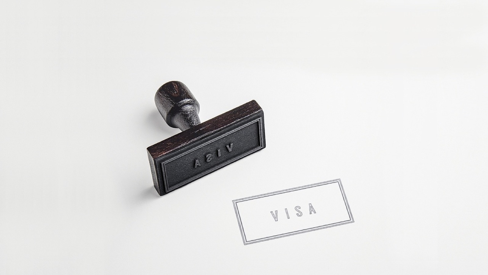 Rubber stamp next to a printed VISA stamp mark on white paper