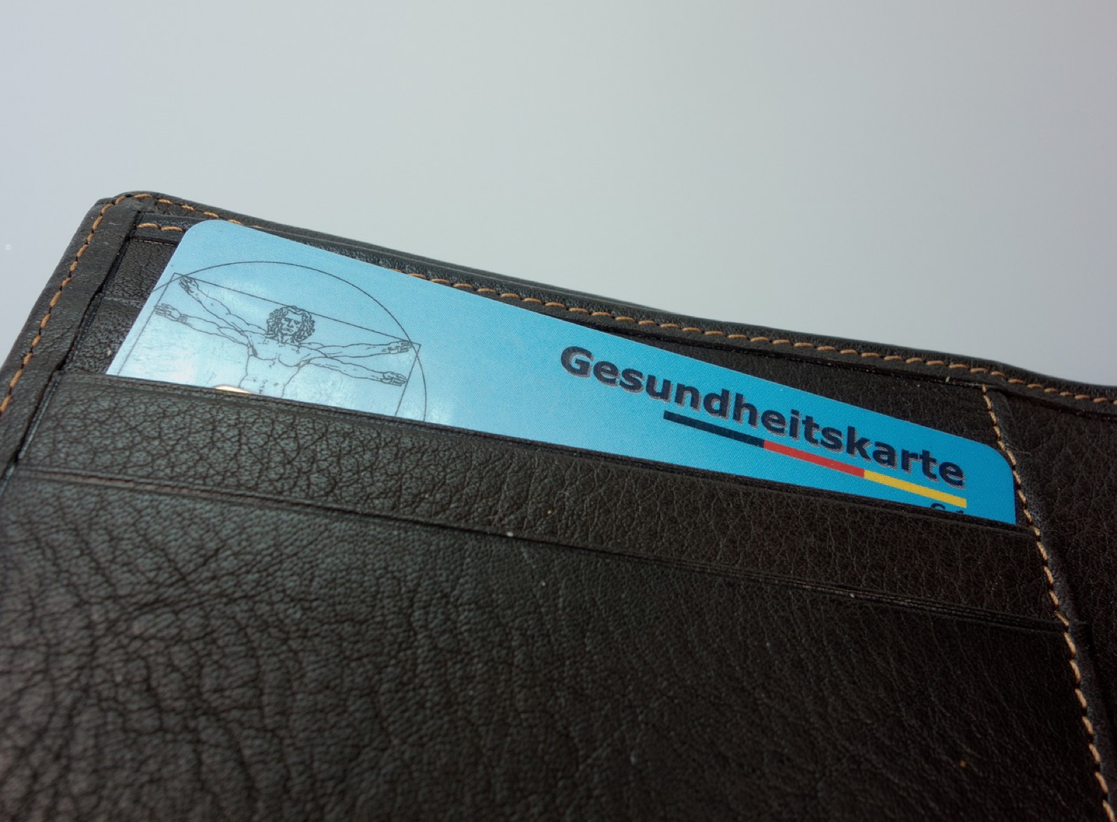Health insurance card tucked into a brown leather wallet